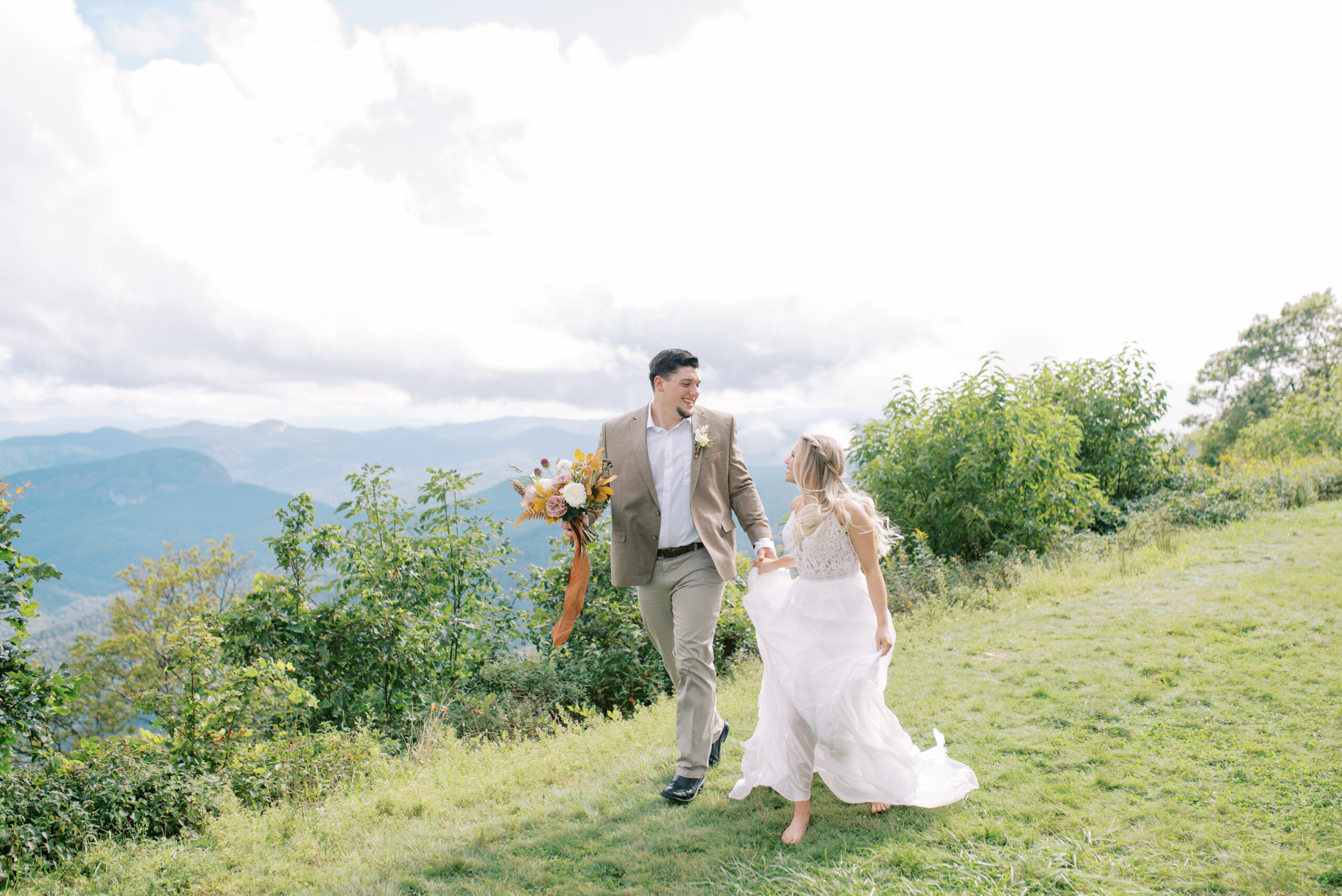 Married couple runs together on a mountaintop in Asheville North Carolina