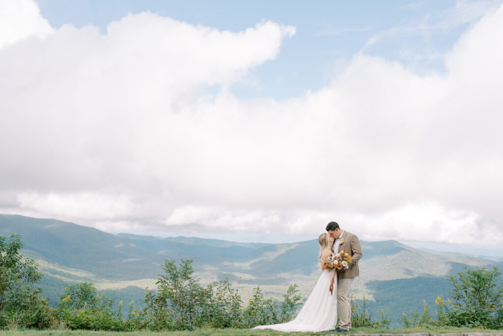 Bride and groom kissing at a mountain overlook in the Blue Ridge Mountains of North Carolina