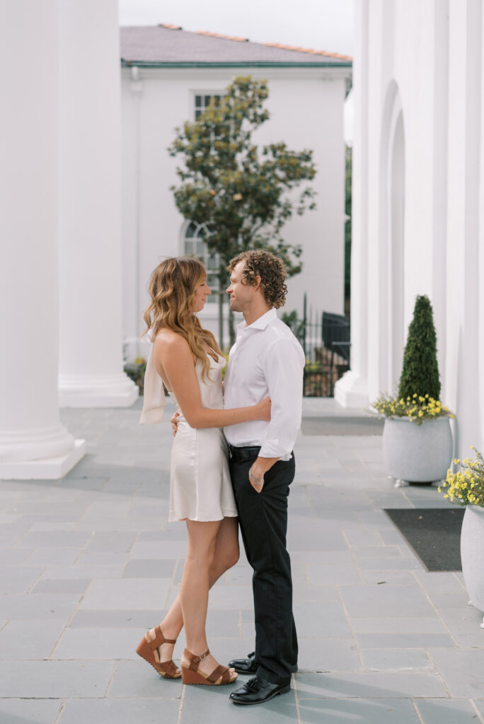 engaged couple holding each other and looking at each other at a church in Charleston