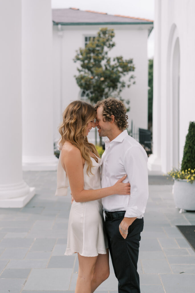 engaged couple stand with their foreheads together smiling with their eyes closed 