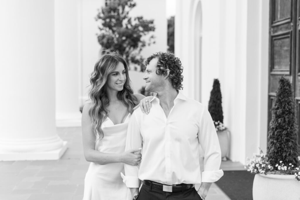 black and white portrait of an engaged couple smiling at each other