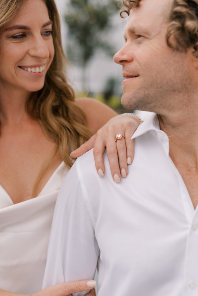 close up of an engaged couple with her ring hand on his shoulder