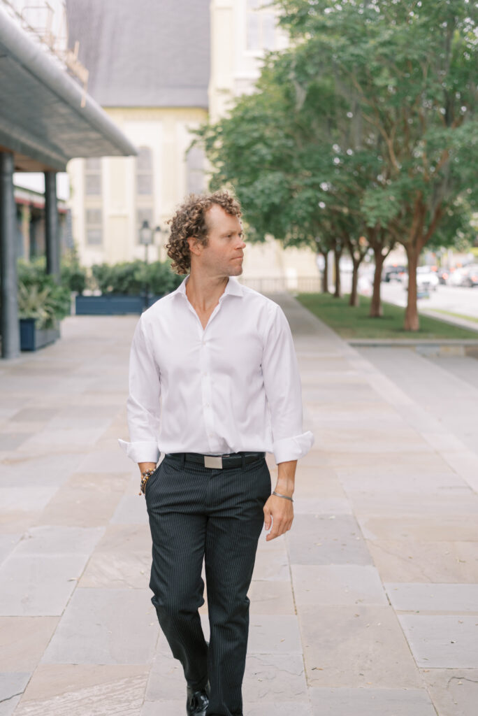 portrait of a man in front of the Dewberry wearing black slacks and a white button down shirt