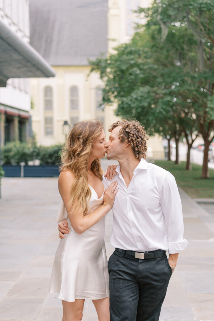 engaged couple kiss in front of the Dewberry in Charleston