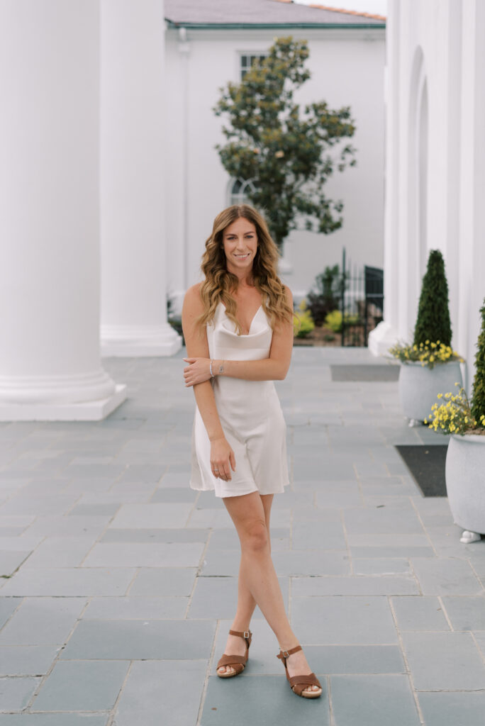 Woman in slip dress smiling on church porch in Charleston