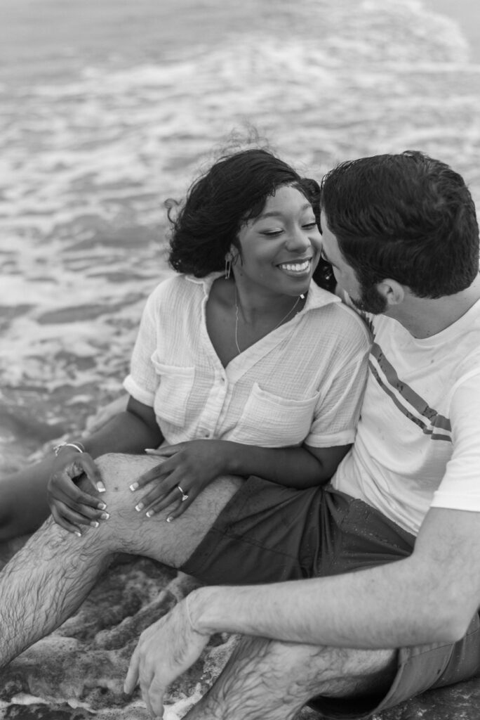 Close up black and white image of a couple sitting in the water