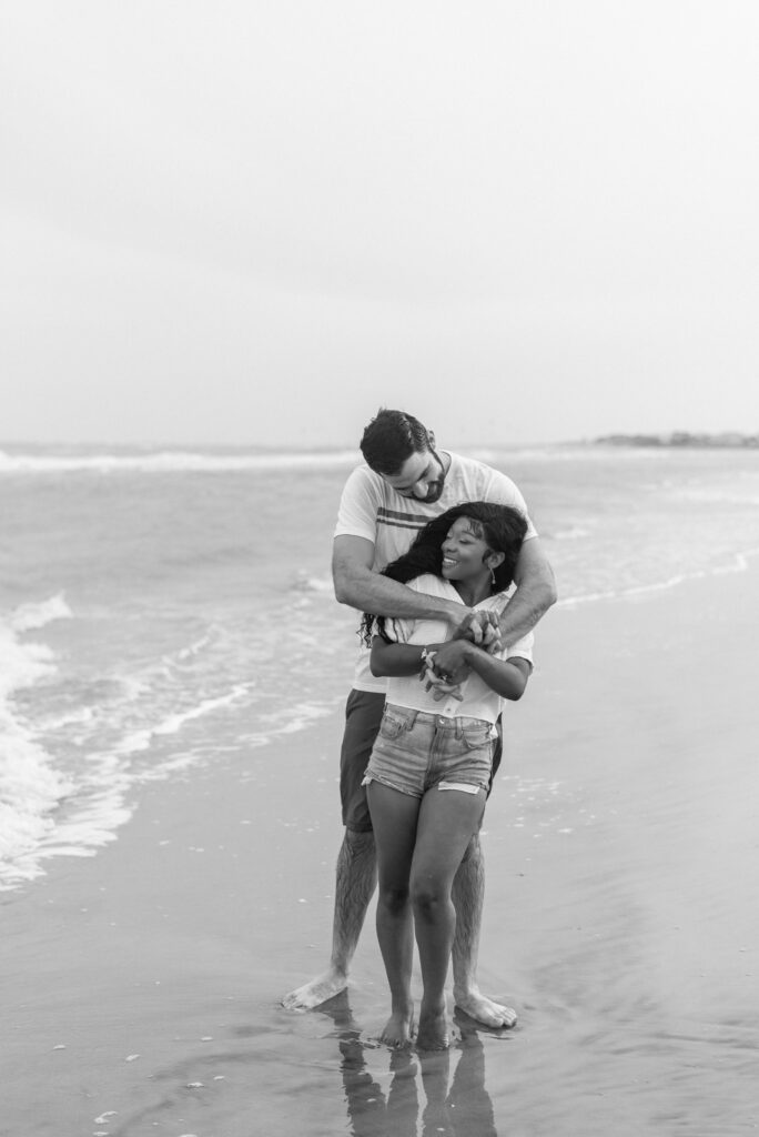 couple hugging on isle of palms beach in black and white