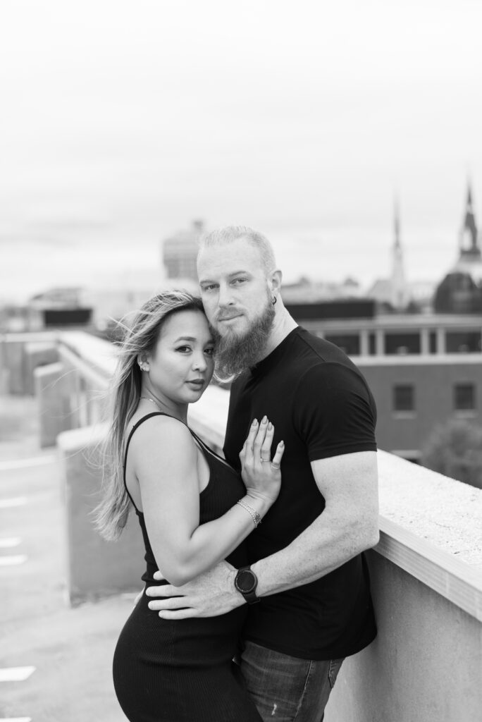 black and white portrait of a couple embracing overlooking downtown Charleston