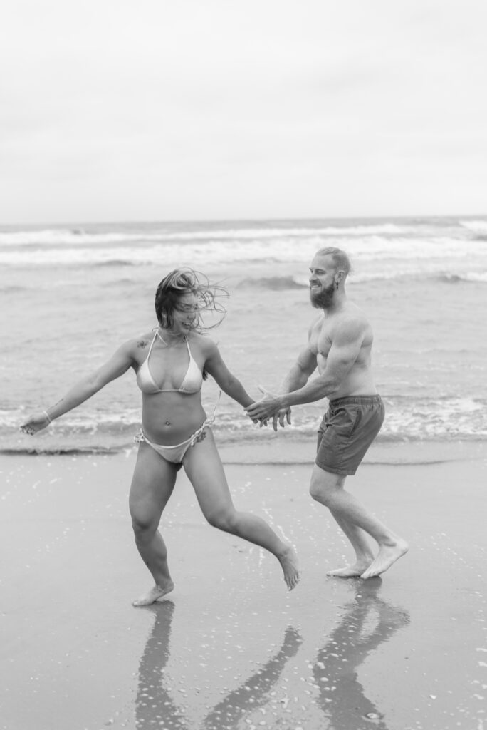 couple playing and chasing each other on the beach 