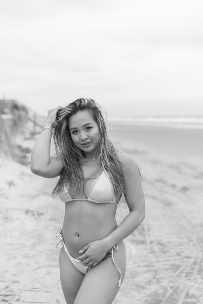 black and white portrait of a woman in a silver bikini on the beach