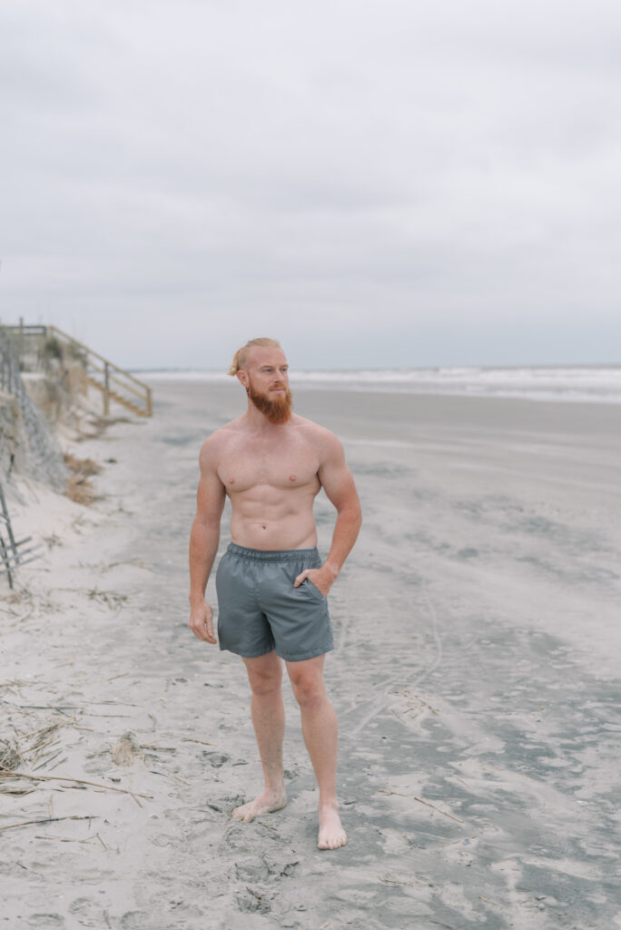 portrait of a man with a beard in gray swim shorts