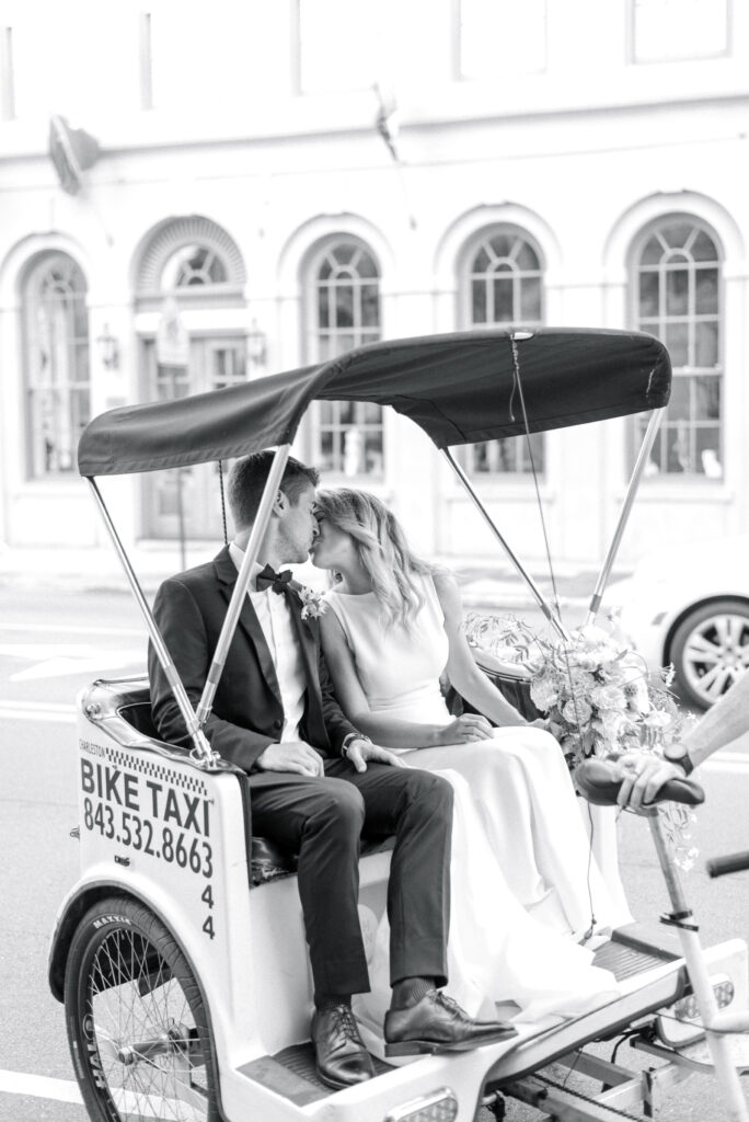 Bride and groom share a kiss in a rickshaw in downtown Charleston SC