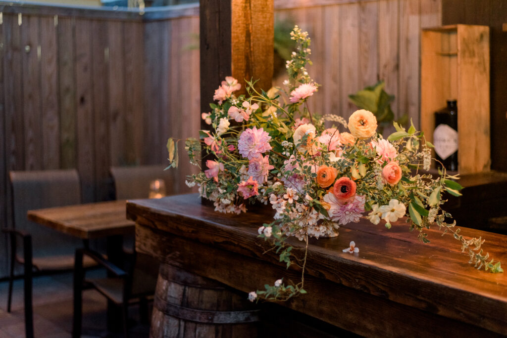 Pastel floral arrangement on the bar at an intimate wedding dinner