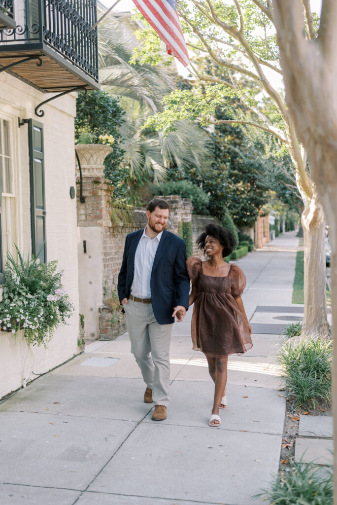 Couple holding hands and smiling in downtown Charleston