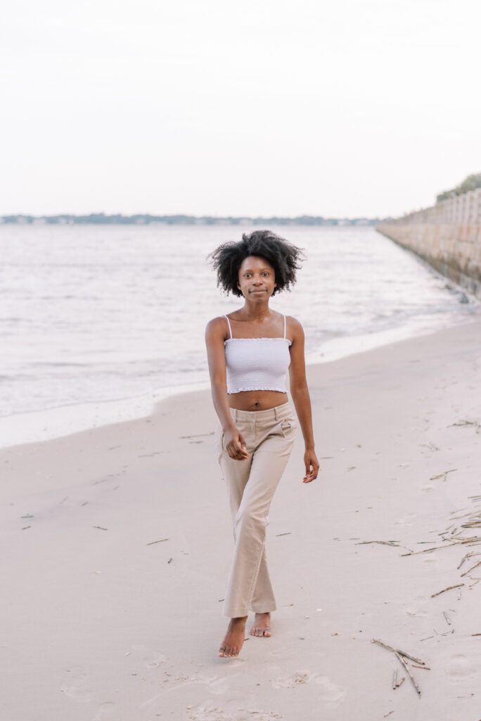 Woman on the beach in khakis and a white crop top