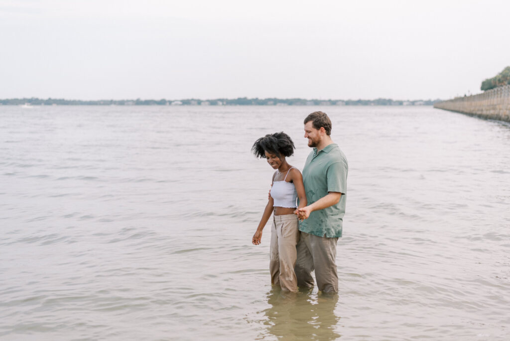 couple stand together in the water at the Charleston battery