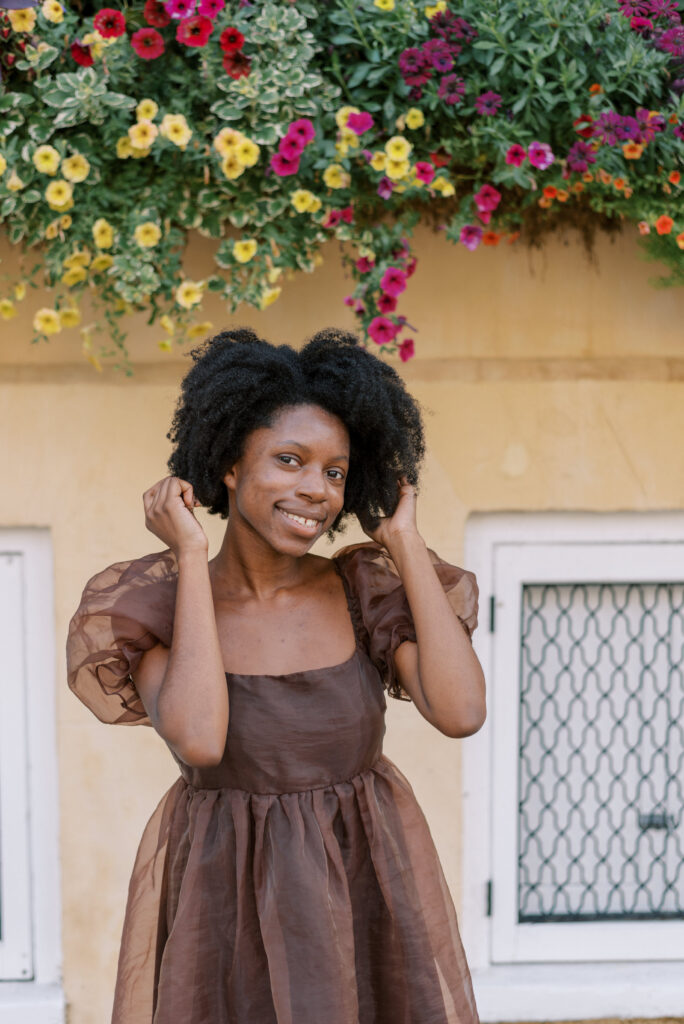 headshot of a woman smiling in front of a yellow house in Charleston