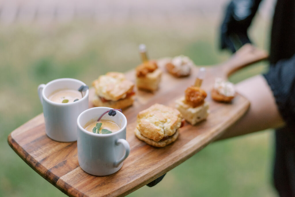 Wooden board with small bites served to the newly married couple at an intimate wedding