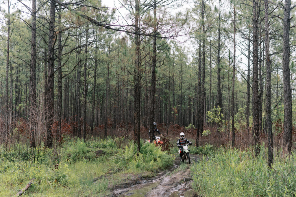 Two dirt bike riders coming towards the camera on a mud trail in the woods of South Carolina