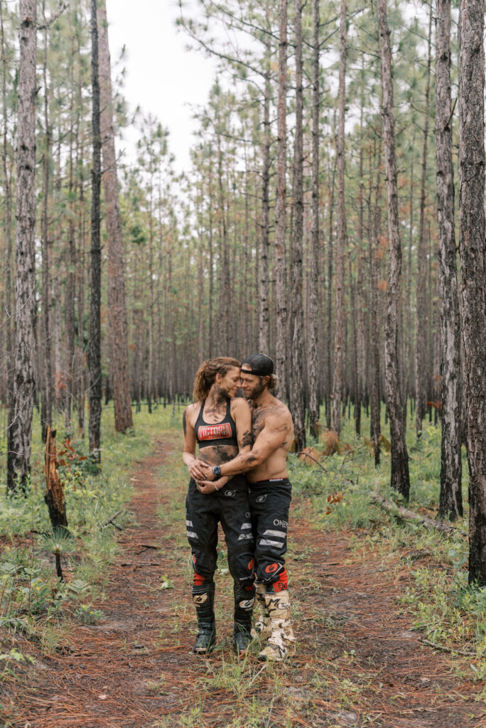 Man wraps his arms around his girlfriend in the middle of the woods during their engagement shoot