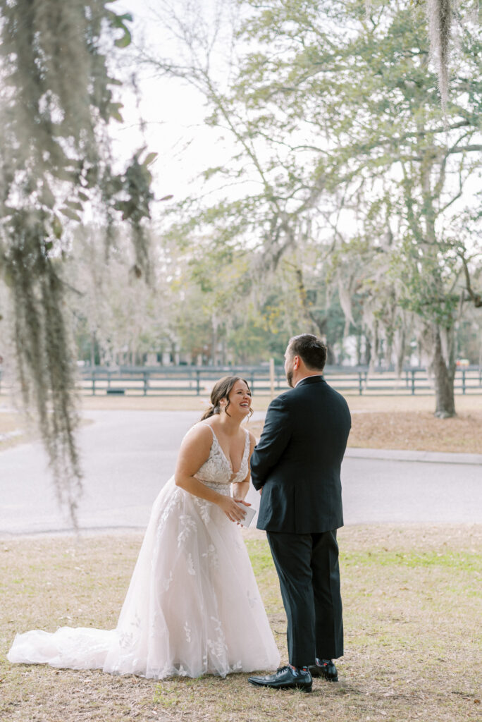 Bride laughs as she reads her vows to her groom