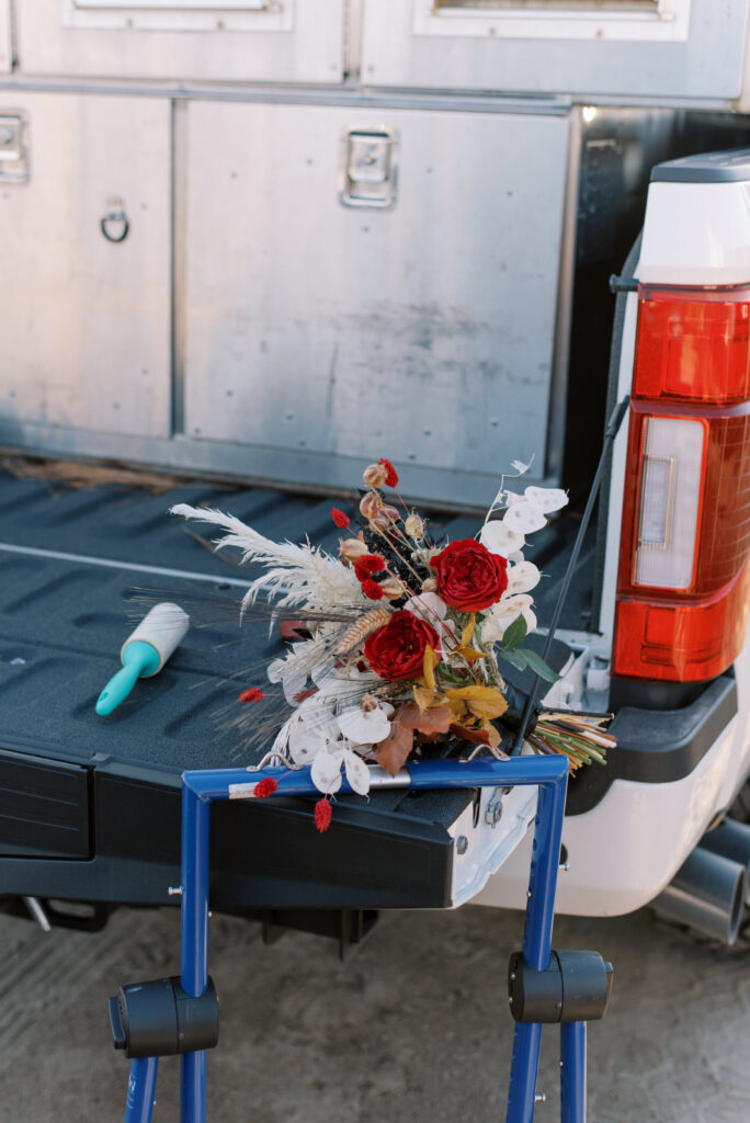 bouquet on the tailgate of a truck before a beach elopement