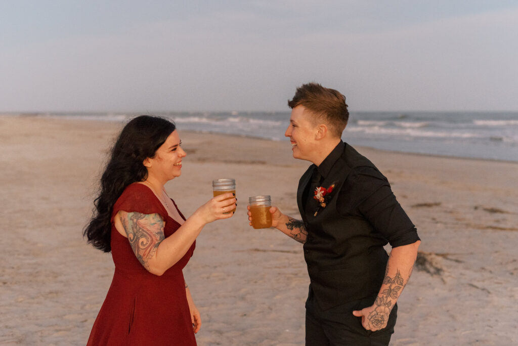 Couple share a toast on the beach after their wedding ceremony